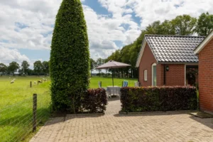 Zijaanzicht van het appartement met schapen in de achtergrond.