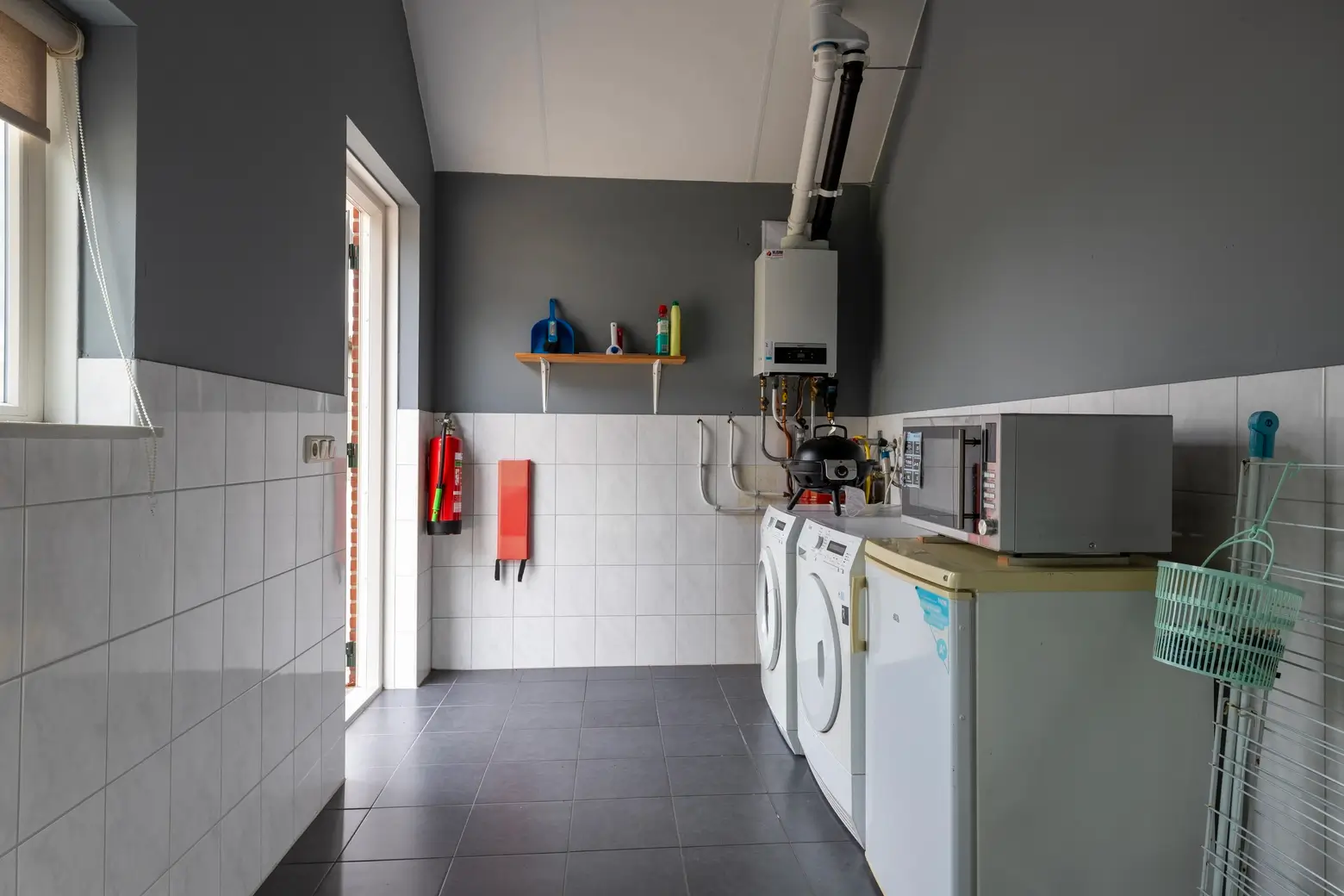 Bijkeuken met magnetron, wasmachine, droger en koelkast