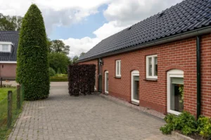 Voorzijde van de accommodatie met groene heggen.