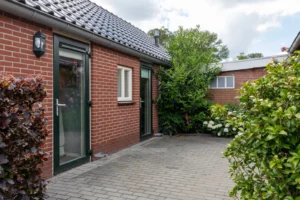 de ingang van de woning omringd door groene planten