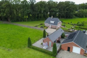 Luchtfoto van de accommodatie omringd door groene weide en bomen.