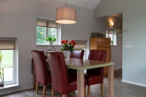 Eethoek met bruine eetkamer tafel en vier rode eetkamerstoelen